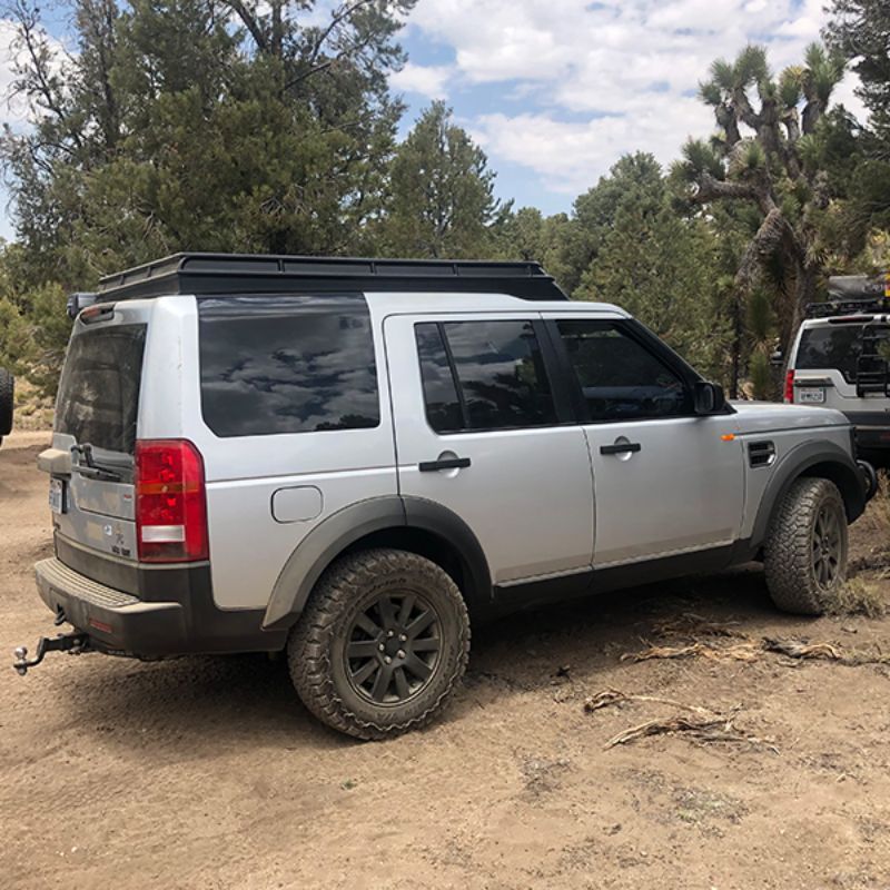 Badass Tents "CONVOY" Land Rover 05-16 LR3  / LR4 Rooftop Tent - PRE-ASSEMBLED. Rear Side view of closed tent on vehicle at campsite