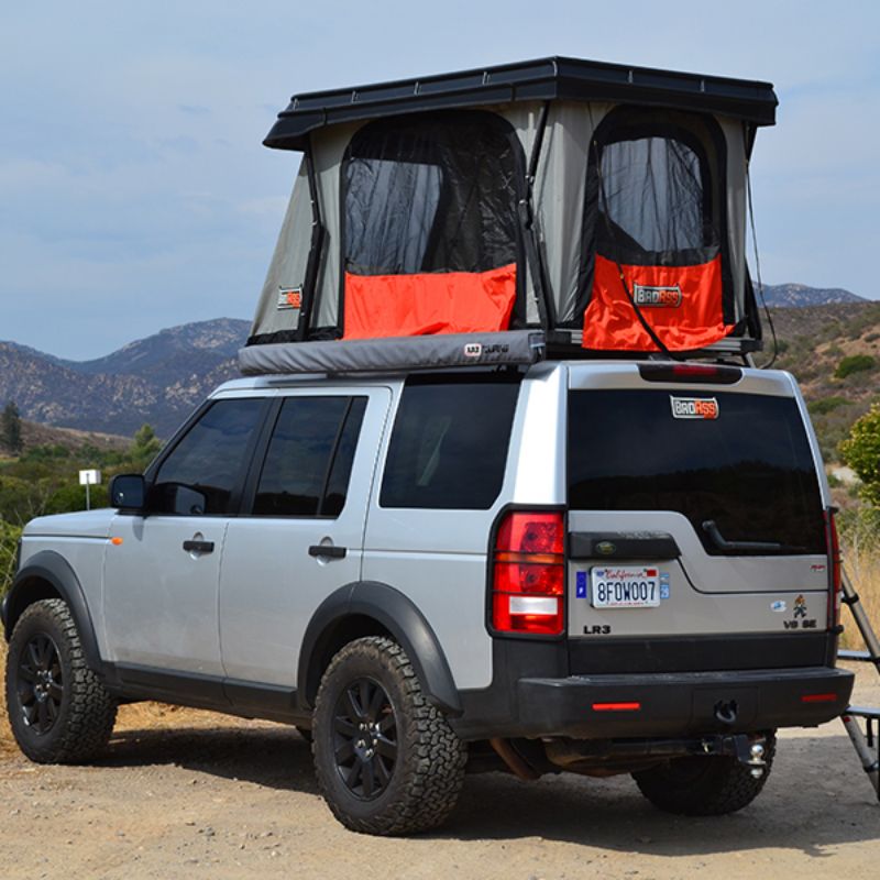 Badass Tents "CONVOY" Land Rover 05-16 LR3  / LR4 Rooftop Tent - PRE-ASSEMBLED. Rear corner view of Open tent on vehicle with ladder at campsite