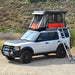 Badass Tents "CONVOY" Land Rover 05-16 LR3  / LR4 Rooftop Tent - PRE-ASSEMBLED. Open tent on vehicle with ladder at campsite