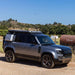 Badass Tents "CONVOY" 2020-23 Land Rover NEW Defender 110 Rooftop Tent PRE-ASSEMBLED. Passenger side view of closed tent on vehicle outside