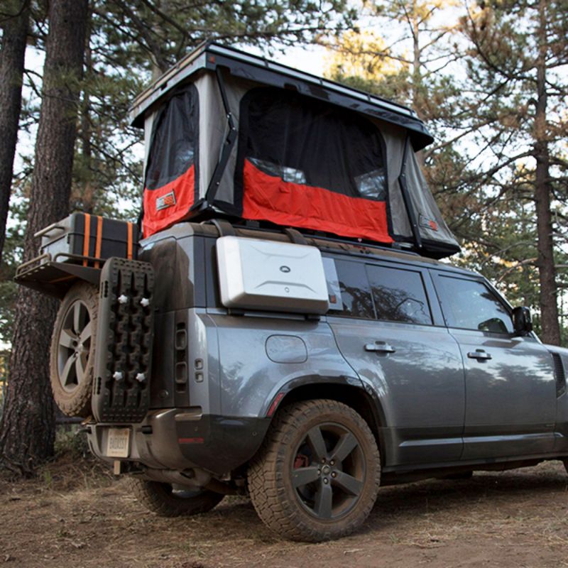 Badass Tents "CONVOY" 2020-23 Land Rover NEW Defender 110 Rooftop Tent PRE-ASSEMBLED.Side view of open tent on vehicle at campsite