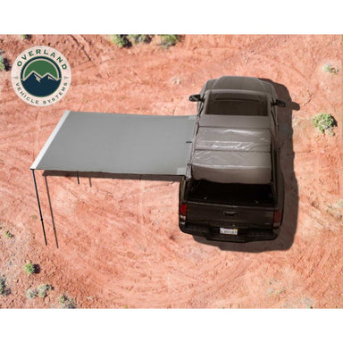 Overland Vehicle Systems Nomadic Awning 2.0 - 6.5' With Black Cover open on dirt