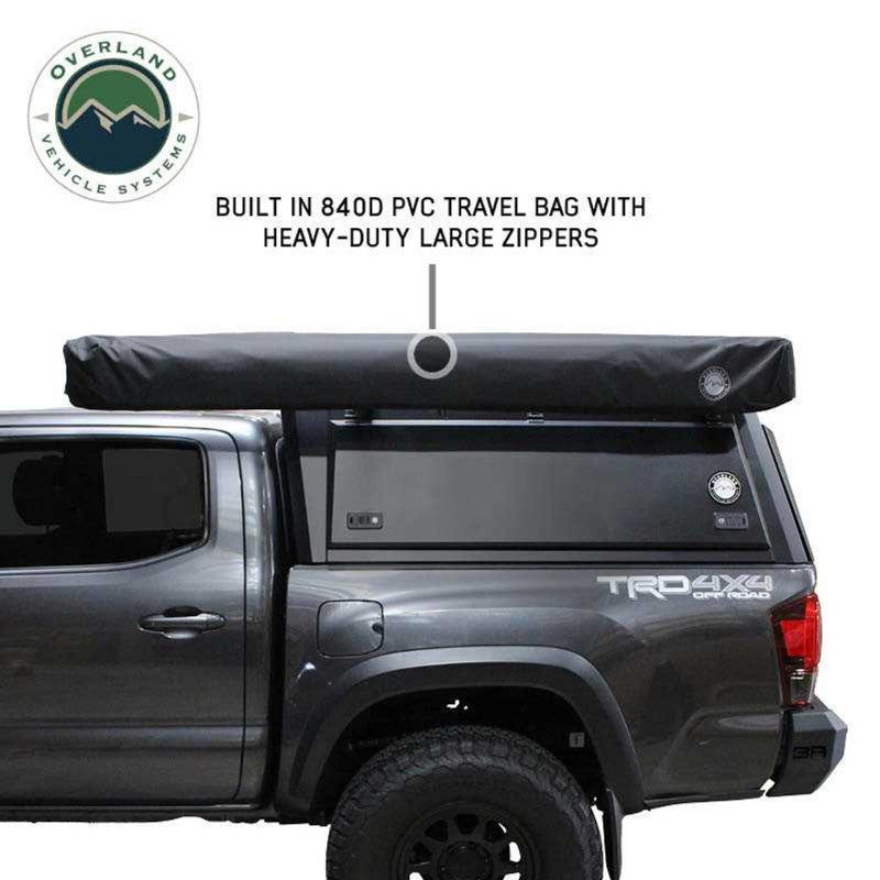 Overland Vehicle Systems XD Nomadic 270 Degree Awning & Wall Kit Combo with Lights, Black Out, Black Body , Trim, And Travel Cover closed side view on white background