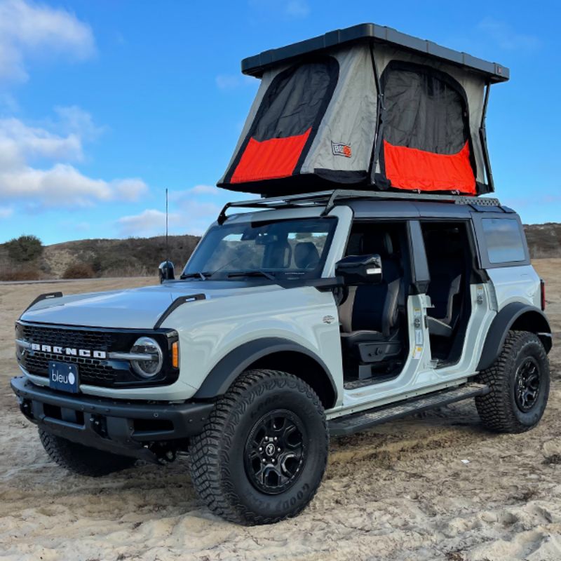 Badass Tents "RECON" Rooftop Tent (Universal Fit) - Onyx Utility Black PRE-ASSEMBLED. Front corner view of open tent with cover on vehicle outside