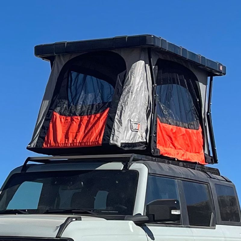 Badass Tents "RECON" Rooftop Tent (Universal Fit) - Onyx Utility Black PRE-ASSEMBLED. Front close view of open tent with cover on vehicle outside