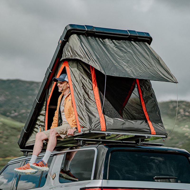 .Badass Tents "RUGGED" Rooftop Tent (Universal Fit). Rear corner view of open tent with person inside on vehicle