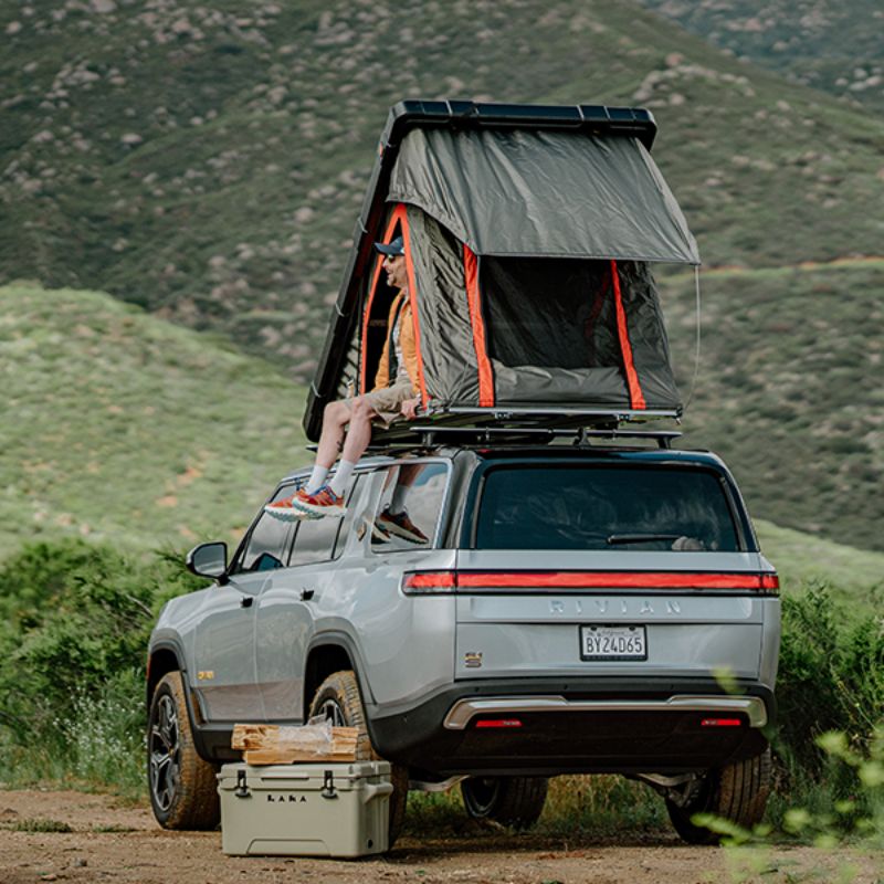 Badass Tents "RUGGED" Rooftop Tent (Universal Fit). Rear corner view of open tent on vehicle outside with person in tent