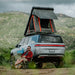 Badass Tents "RUGGED" Rooftop Tent (Universal Fit). Rear corner wide view of open tent on vehicle outside with person sitting in chair