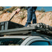 Front Runner Toyota Tacoma (2005-Current) Slimline II Roof Rack Kit.Person standing on roof rack on vehicle attaching gear