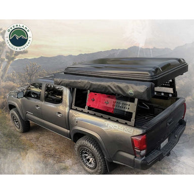 Overland Vehicle Systems Discovery Rack - Mid Size Truck Short Bed Application top angled view installed on truck outdoors with gear
