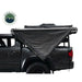 Overland Vehicle Systems Nomadic Awning 180 - Dark Gray With Black Cover side view on vehicle on white background