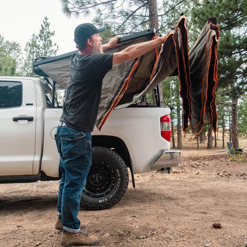 Tuff Stuff Overland 270 Degree Awning, XL, Passenger Side, C-Channel Aluminum, Olive man assembling awning outdoors