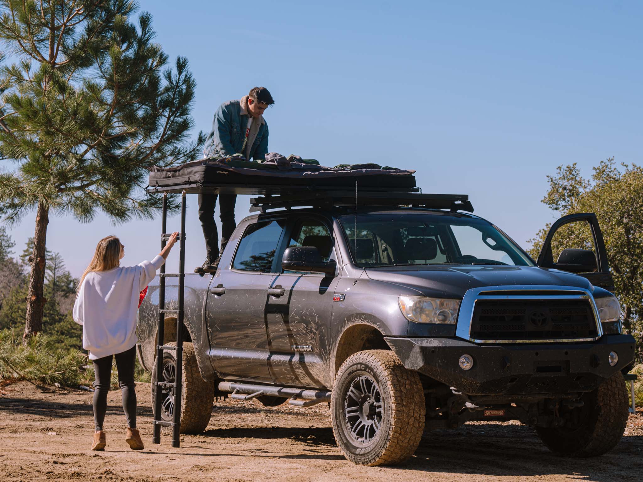 SCOUT DESERT FOREST people assembling tent on truck