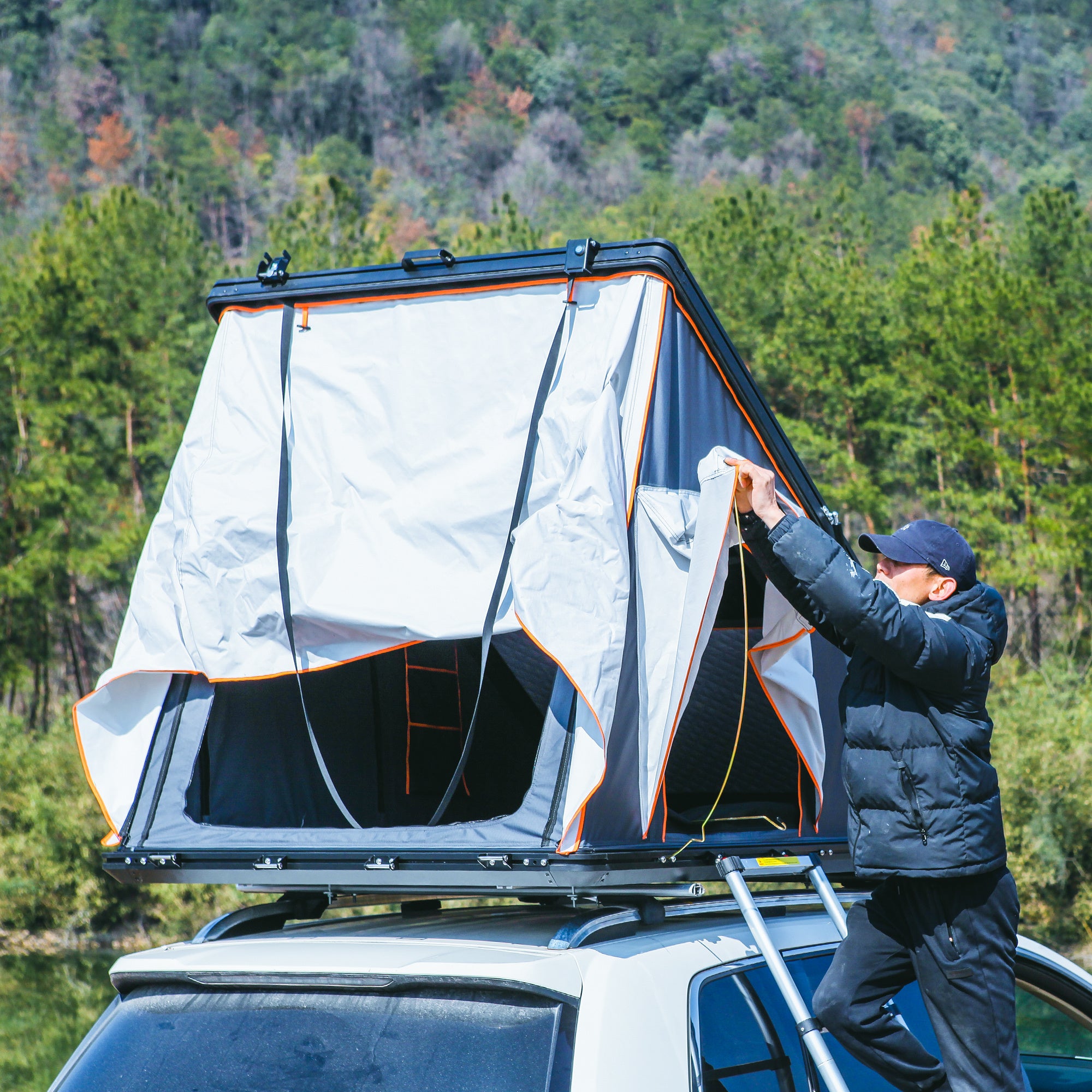 Trustmade Scout Pro Series - Triangular Hard Shell Rooftop Tent man opening tent door on vehicle outside