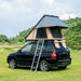 Trustmade Scout MAX Series - Triangular Hard Shell Rooftop Tent assembled on suv outside on grass with ladder