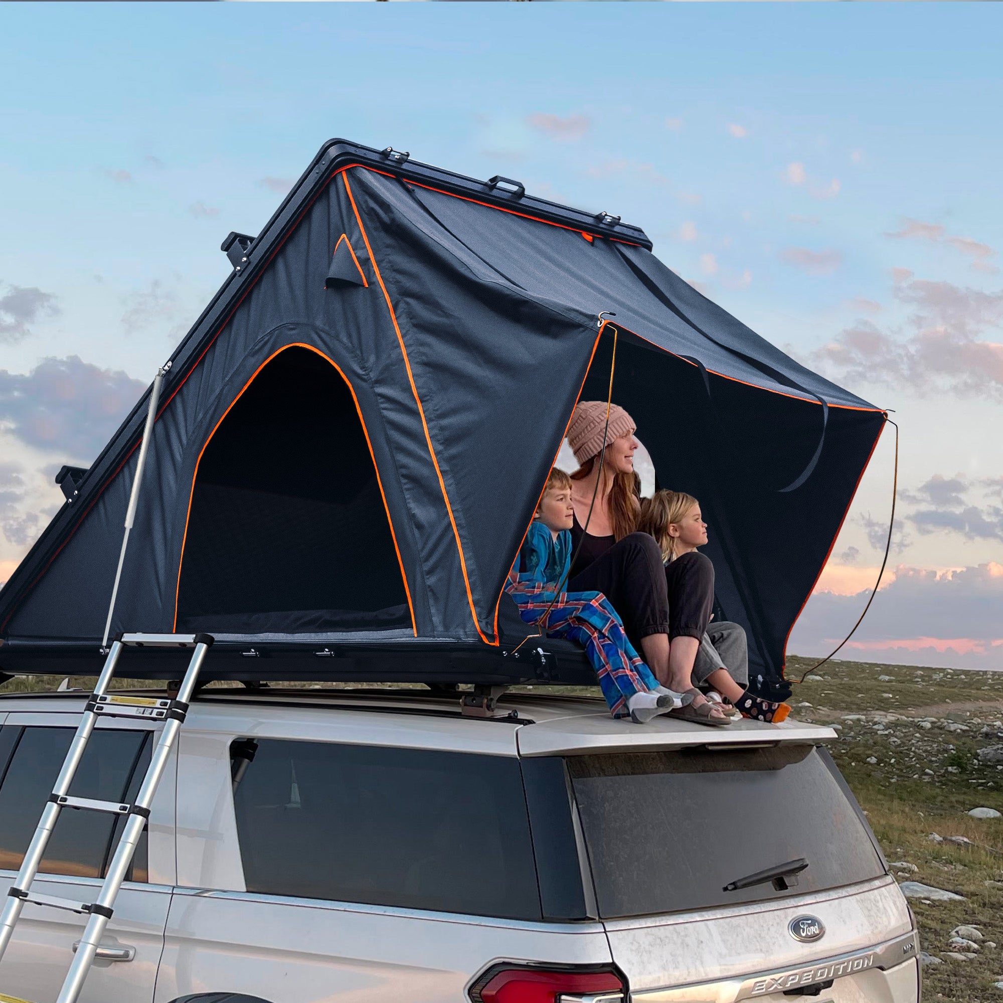 Trustmade Scout Plus Series - Triangular Hard Shell Rooftop Tent with Roof Rack assembled on vehicle with people inside