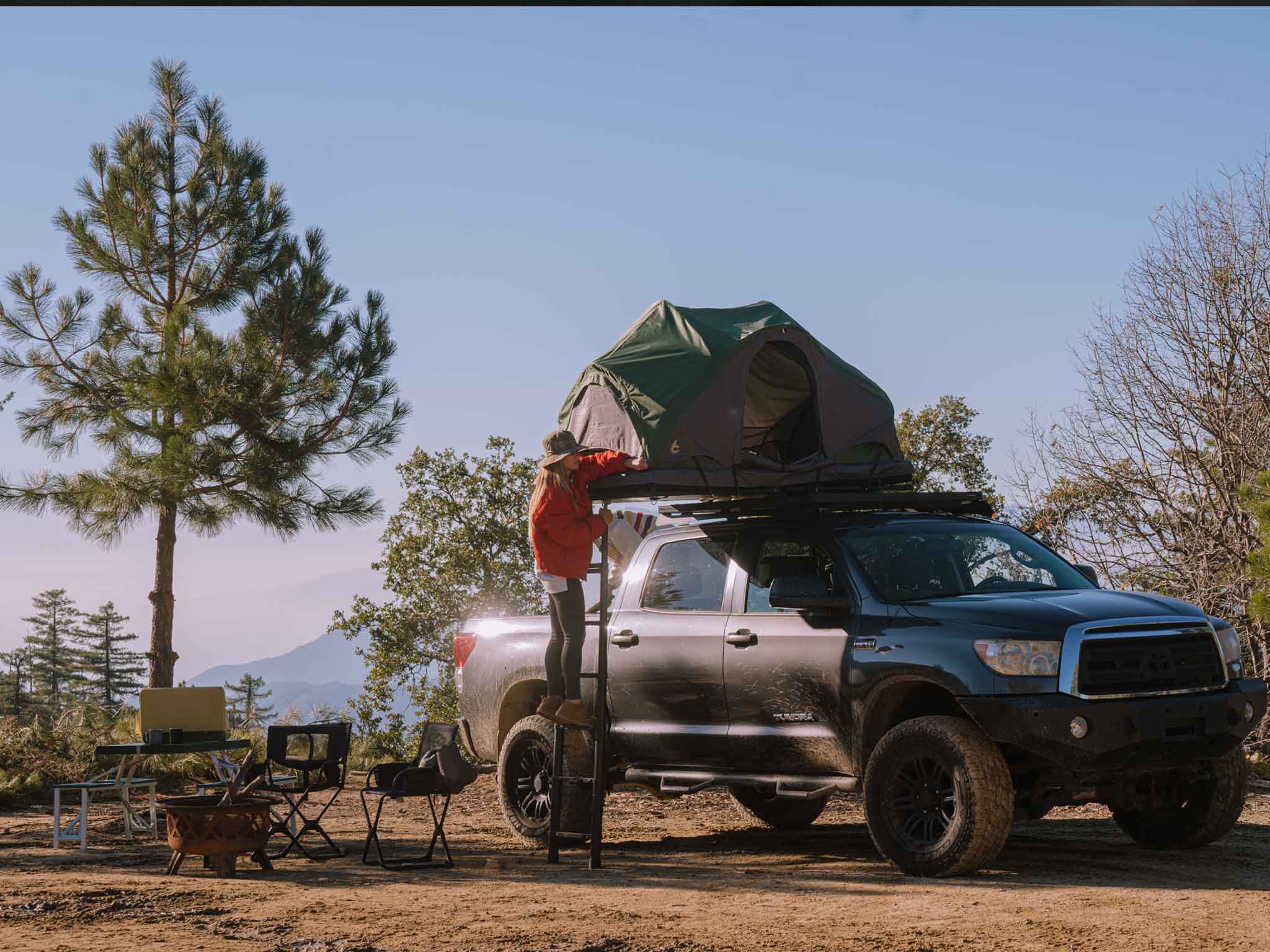 Rev Platform x SCOUT DESERT FOREST closed on truck with man on ladder at campsite